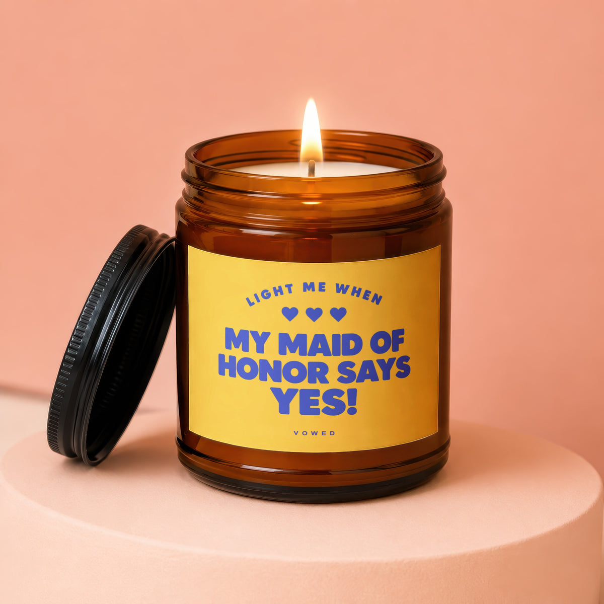 Amber candle with lit wick and lid off, reads "MY MAID OF HONOR SAYS YES!".