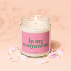 Jar candle labeled "In my newlywed era" with pink petals.