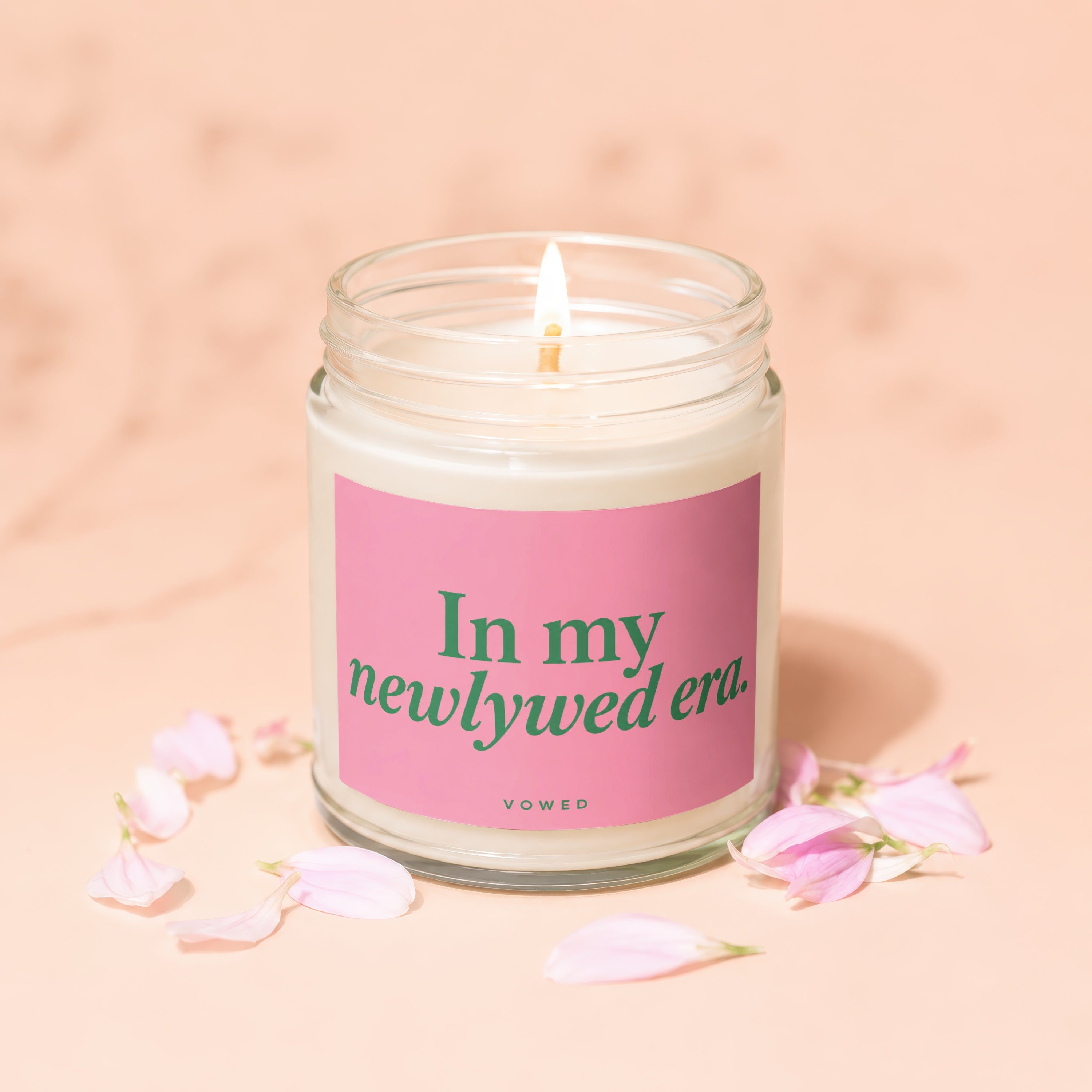Jar candle labeled "In my newlywed era" with pink petals.