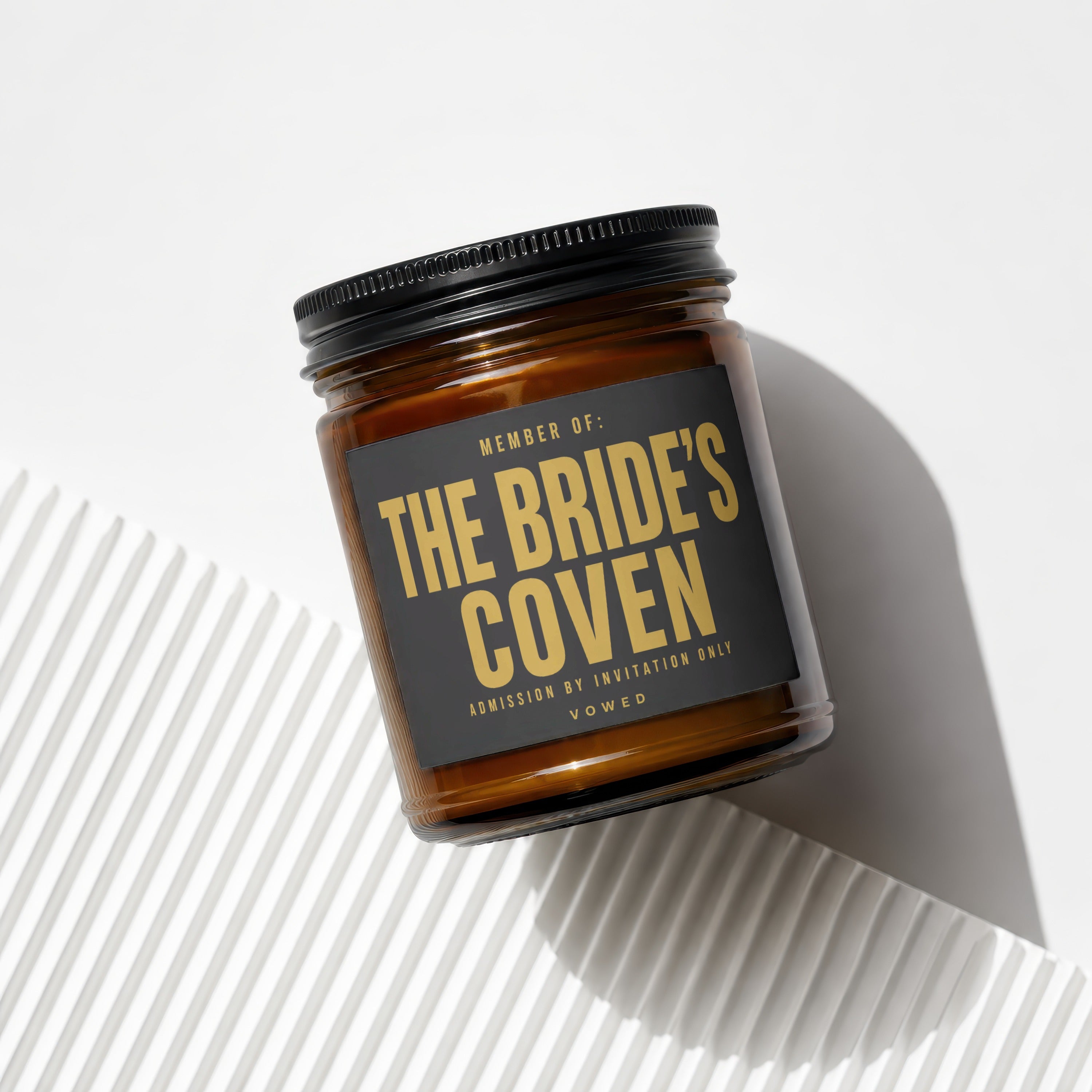 Amber candle with black lid, label reads "THE BRIDE'S COVEN".