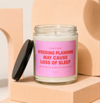 Glass candle with pink label that reads "Wedding planning may cause loss of sleep."