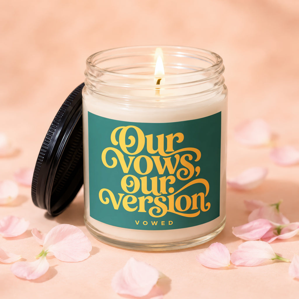 Candle with lit wick and lid off, label reads "Our Vows, Our Version VOWED".