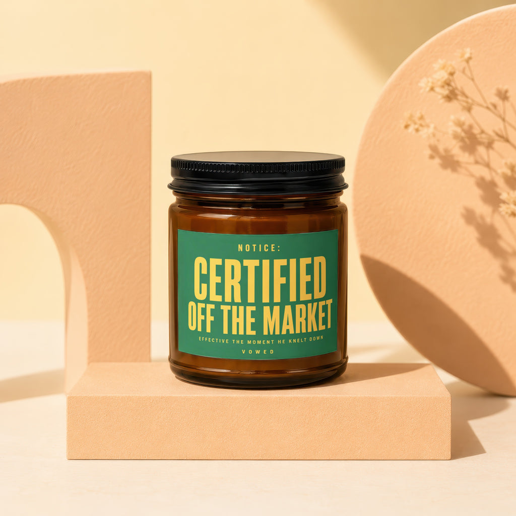 Amber jar candle with green label reading "NOTICE: CERTIFIED OFF THE MARKET VOWED".