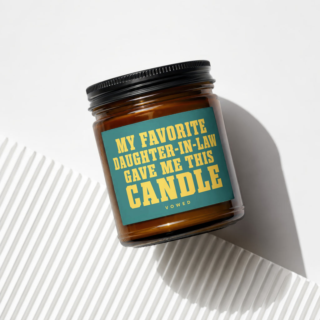 Amber glass candle with dark lid and teal label saying "My favorite daughter-in-law gave me this candle."