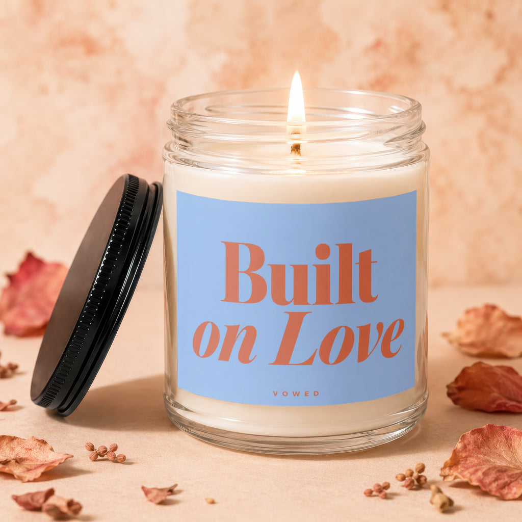 Candle with blue label reading "Built on Love" and "Vowed".