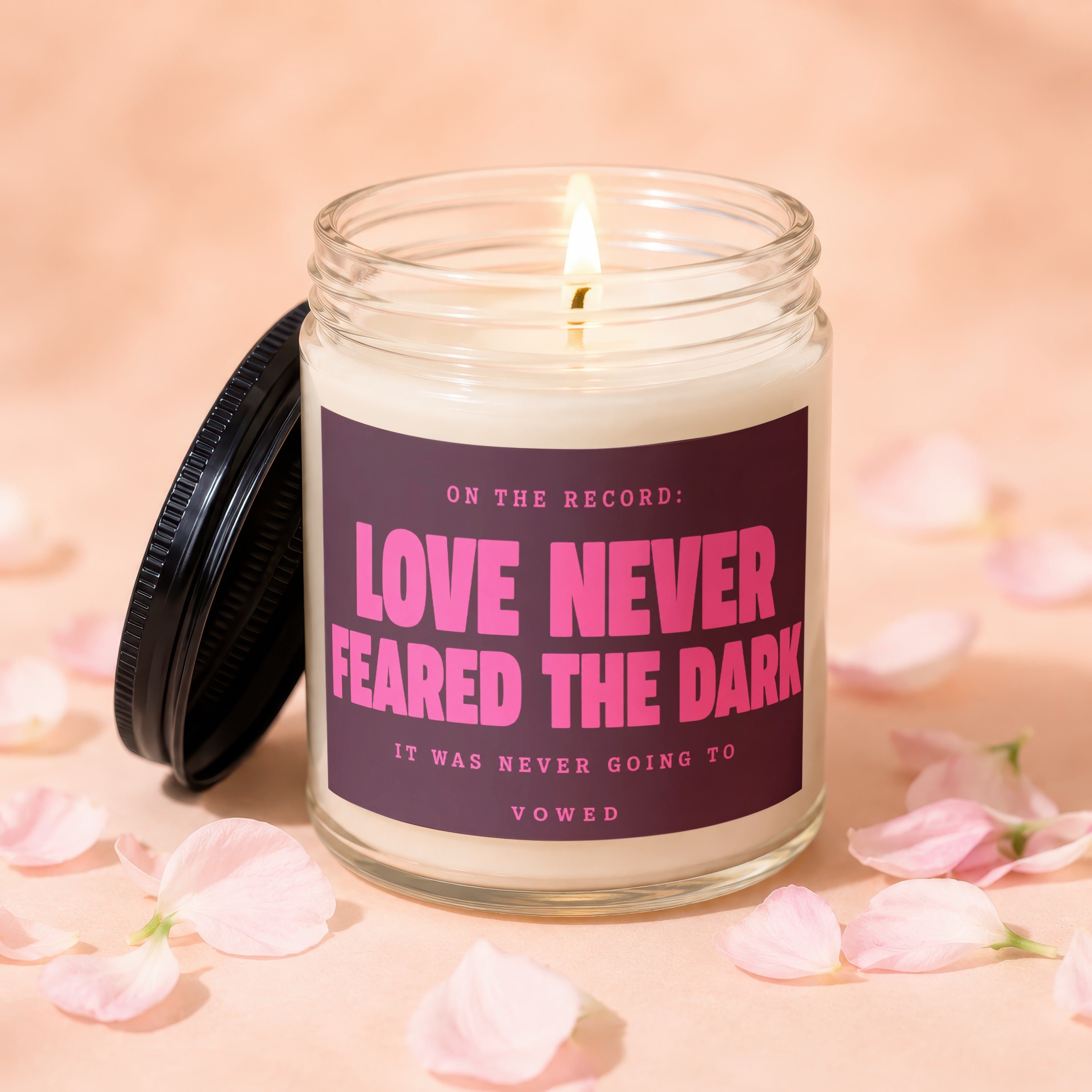 Candle with burning wick labeled "Love Never Feared the Dark."