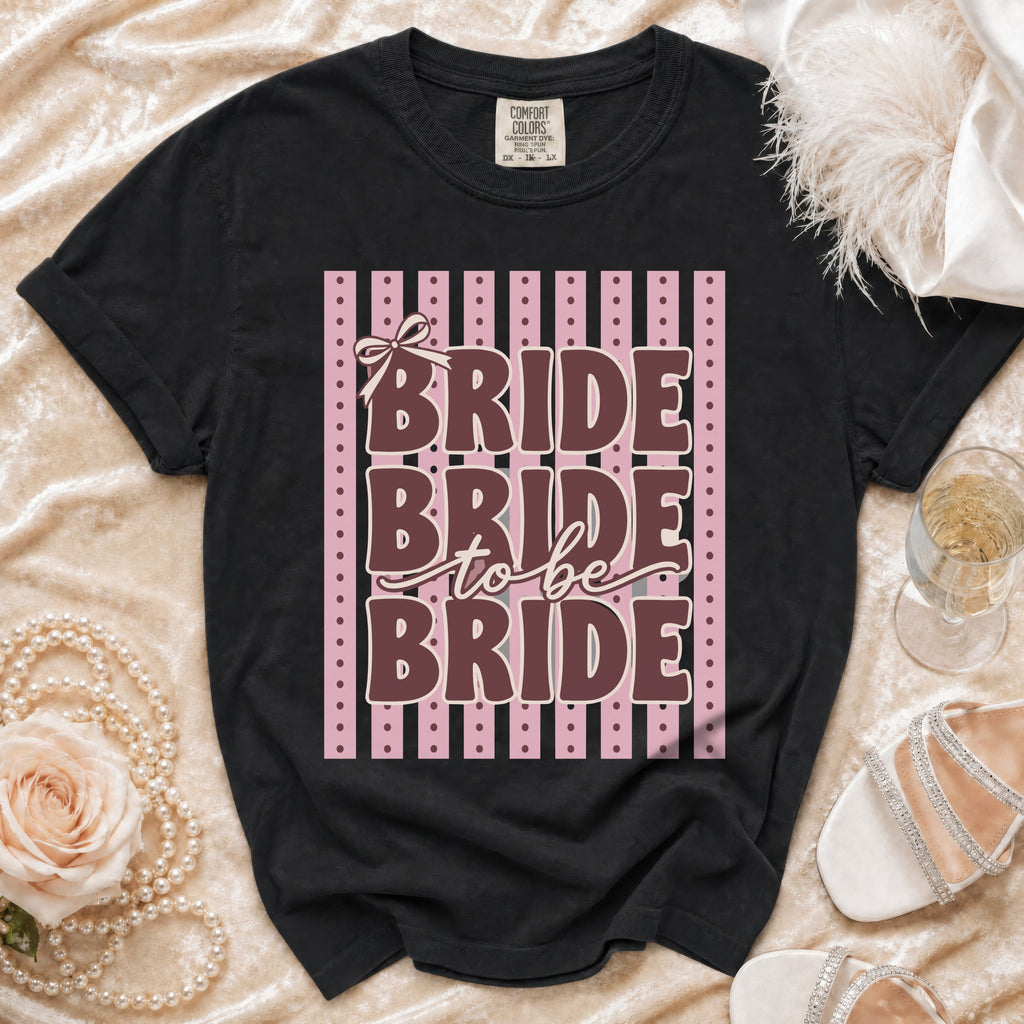Black t-shirt with "Bride to Be Bride" text and a bow on pink stripes.
