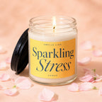 Glass jar candle with lit wick, yellow label reads "Smells Like Sparkling Stress Vowed".
