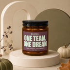 Brown glass candle with "ROSTER: ONE TEAM, ONE DREAM" text.