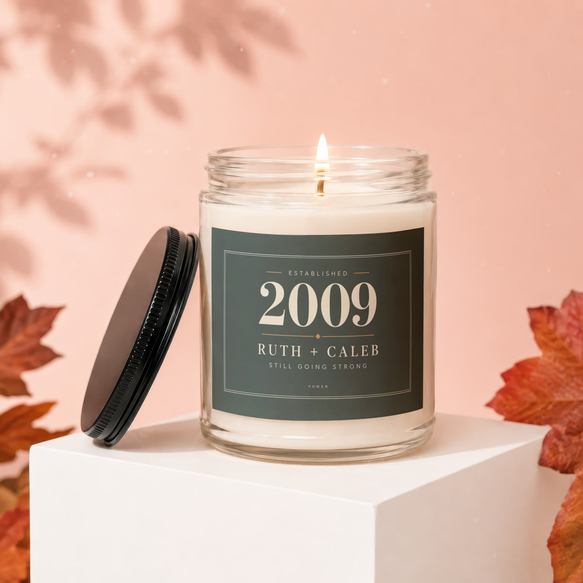 Glass candle labeled "Established 2009 Ruth + Caleb Still Going Strong."
