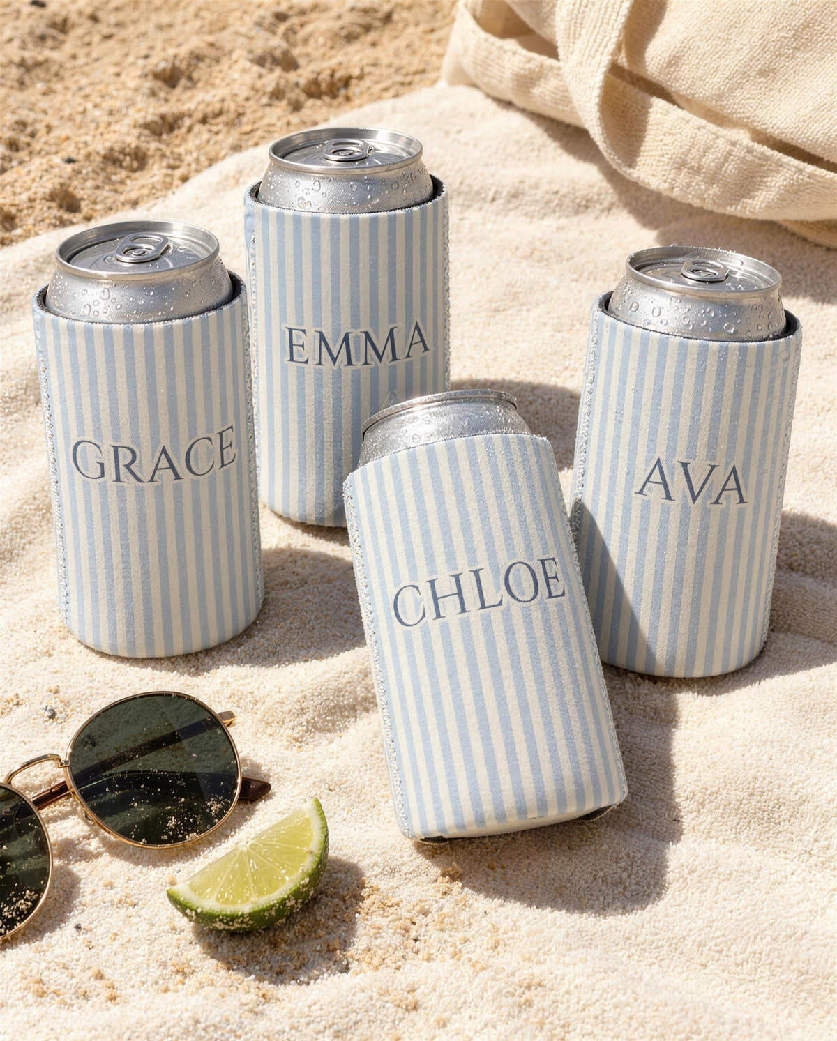 Pinstripe can coolers with the names Grace, Emma, Chloe and Ava on a beach towel