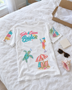 Turks and Caicos Bride Doodles T-shirt, laid on a bed