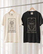 The Bride & Coven Tarot bride and crew shirts: Ivory bride shirt and Black crew shirt on wooden hangers
