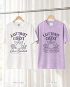 White bride shirt printed in Grape next to an Orchid crew shirt printed in Grape, on hangers